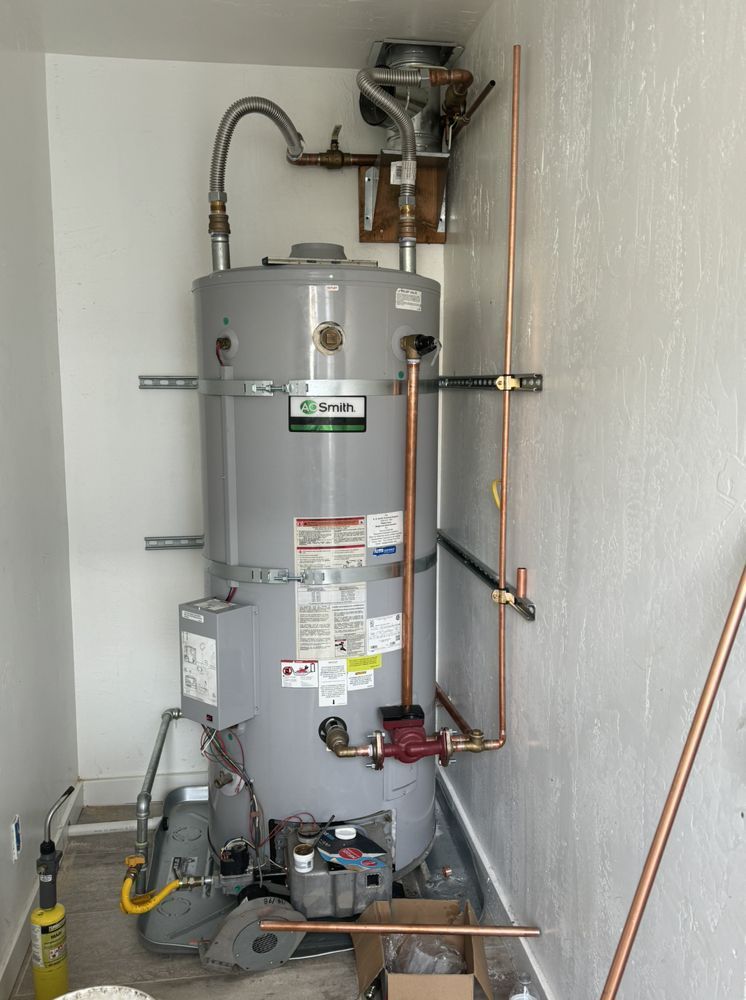 A Water Heater Is Sitting in A Room Next to A Wall – Hayward, Ca – Plumbing 1 Builders Inc.