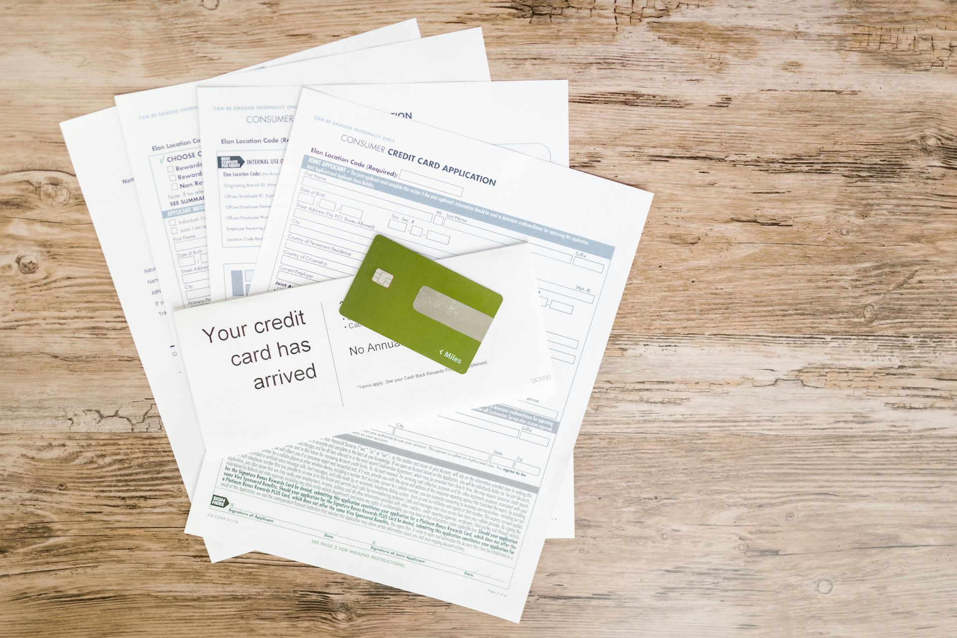Pile of papers with a green credit card and a note that says 