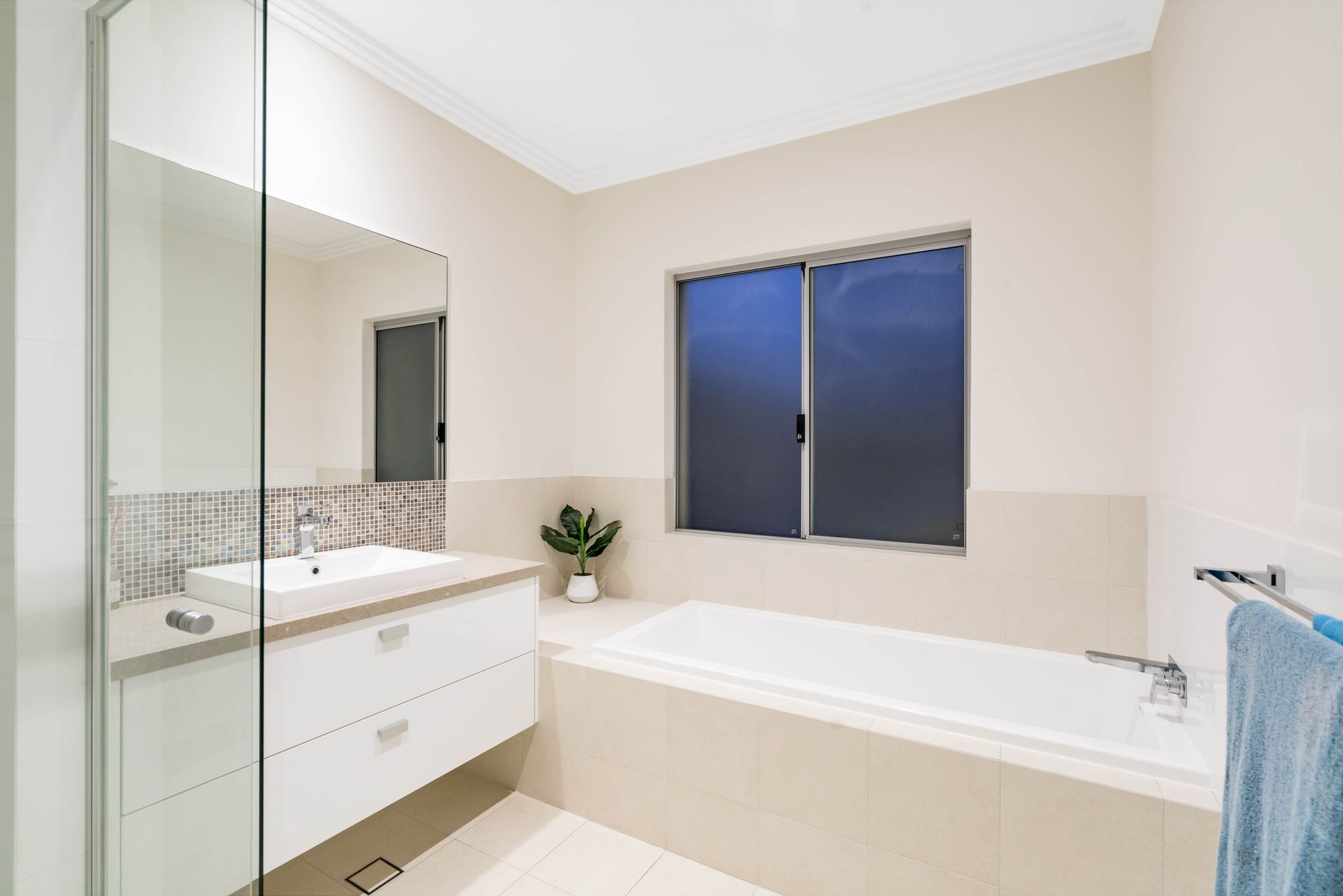 A Bathroom With a Tub, Sink, Mirror and Window — Knobel Builders In Balgownie, NSW