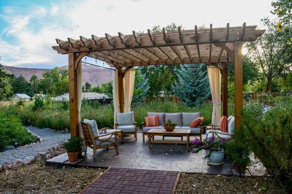 There is a Pergola With a Couch and Chairs Underneath It — Knobel Builders In Balgownie, NSW