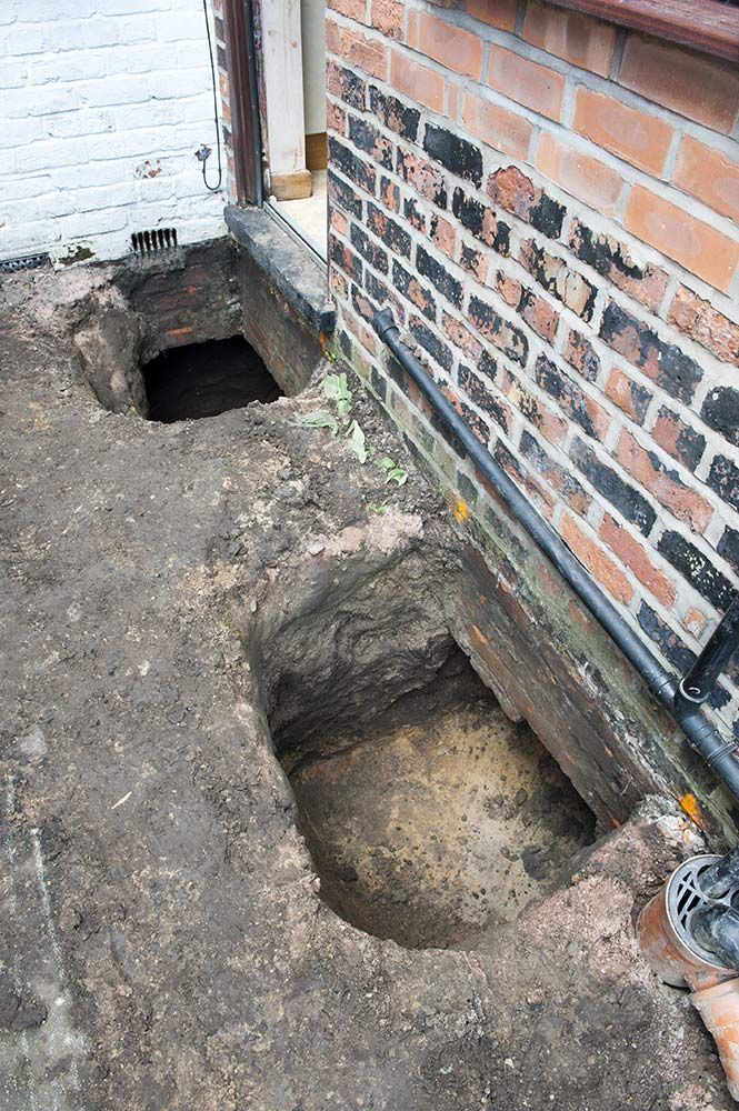 A Hole in the Ground Next to a Brick Wall — Knobel Builders In Balgownie, NSW