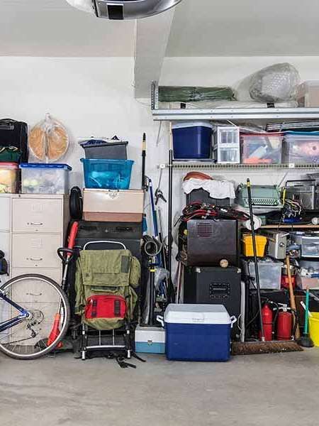 A garage filled with lots of items and a bicycle.