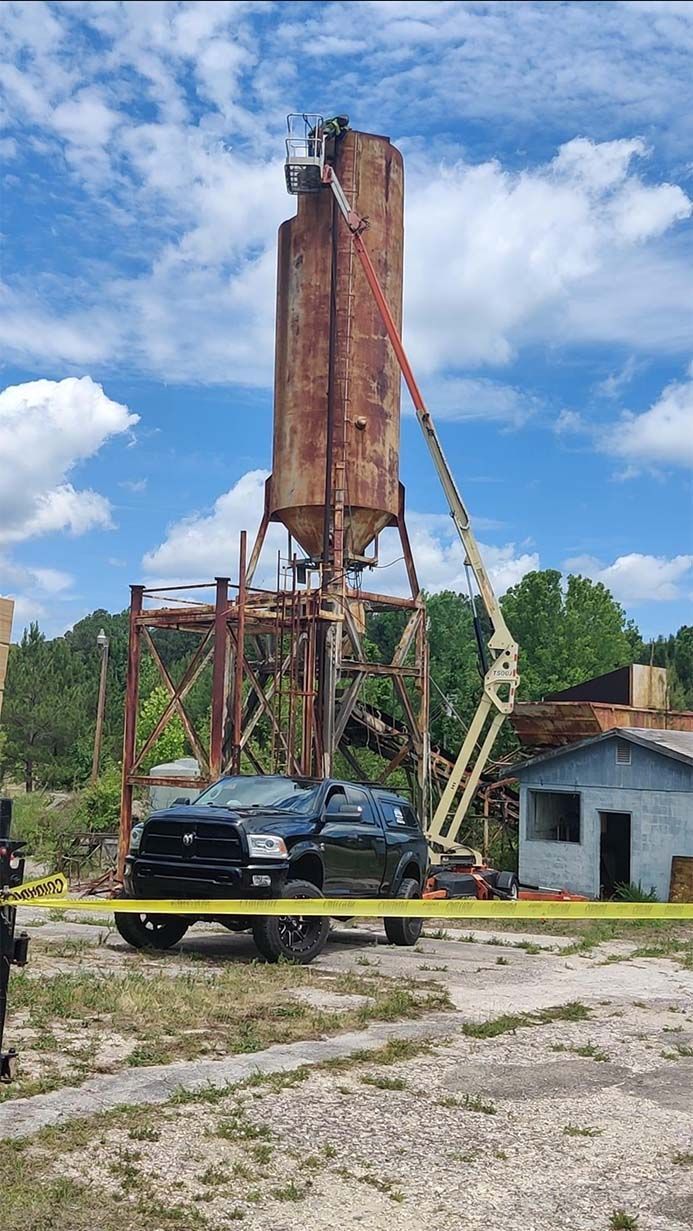 A truck is parked in front of a large silo.
