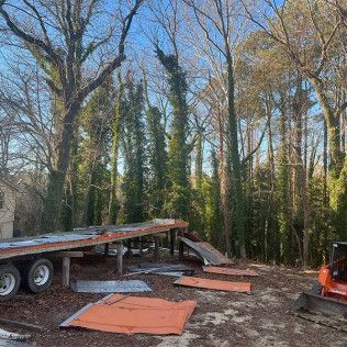 A flatbed truck is parked in the middle of a forest.