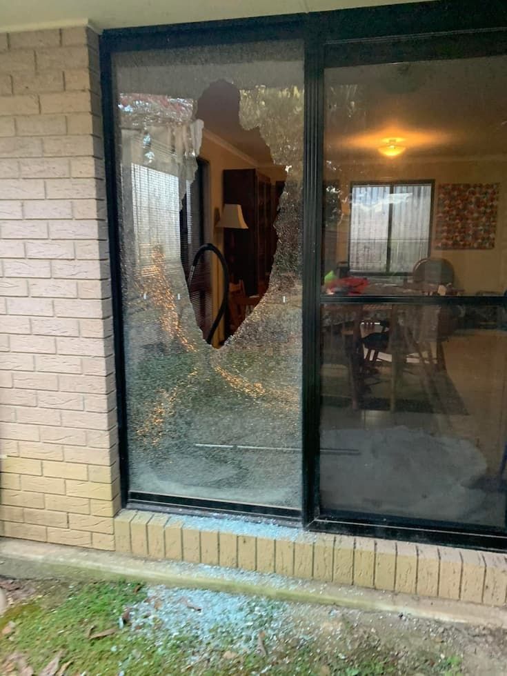 A Large Glass Window is Shattered With a Jagged Hole