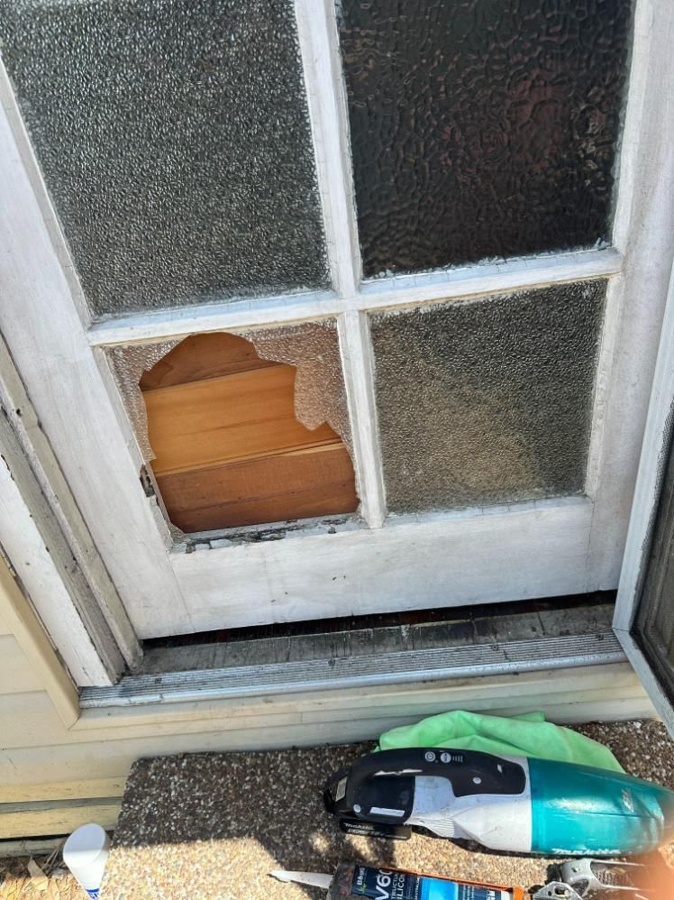 A Broken Glass Door With A Piece Of Wood In It — Central Coast Glass & Glazing In Woy Woy, NSW