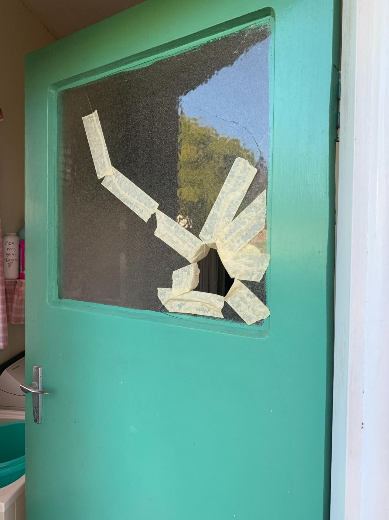 A Green Door With A Broken Window And Tape On It — Central Coast Glass & Glazing In Umina Beach, NSW