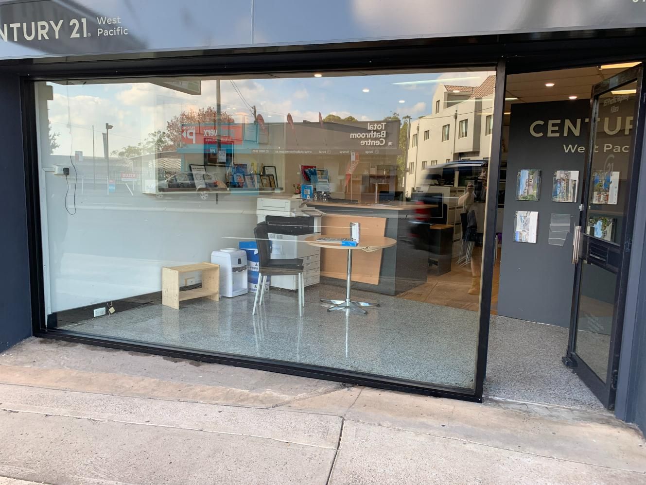 A Store Front With A Sliding Glass Door And A Table And Chairs — Central Coast Glass & Glazing In Umina Beach, NSW