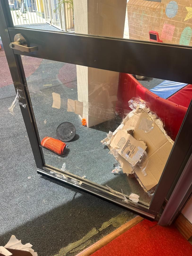 A Broken Glass Door Is Sitting On The Floor In A Room — Central Coast Glass & Glazing In Tuggerah, NSW