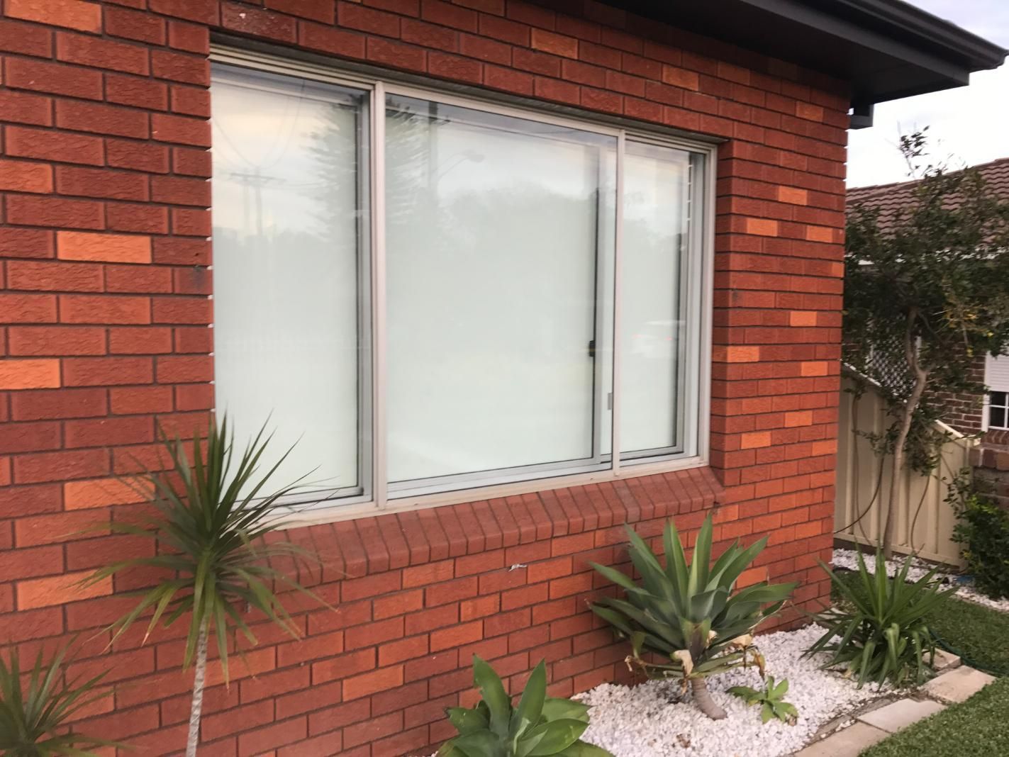 There Is A Large Window On The Side Of A Brick House — Central Coast Glass & Glazing In Umina Beach, NSW