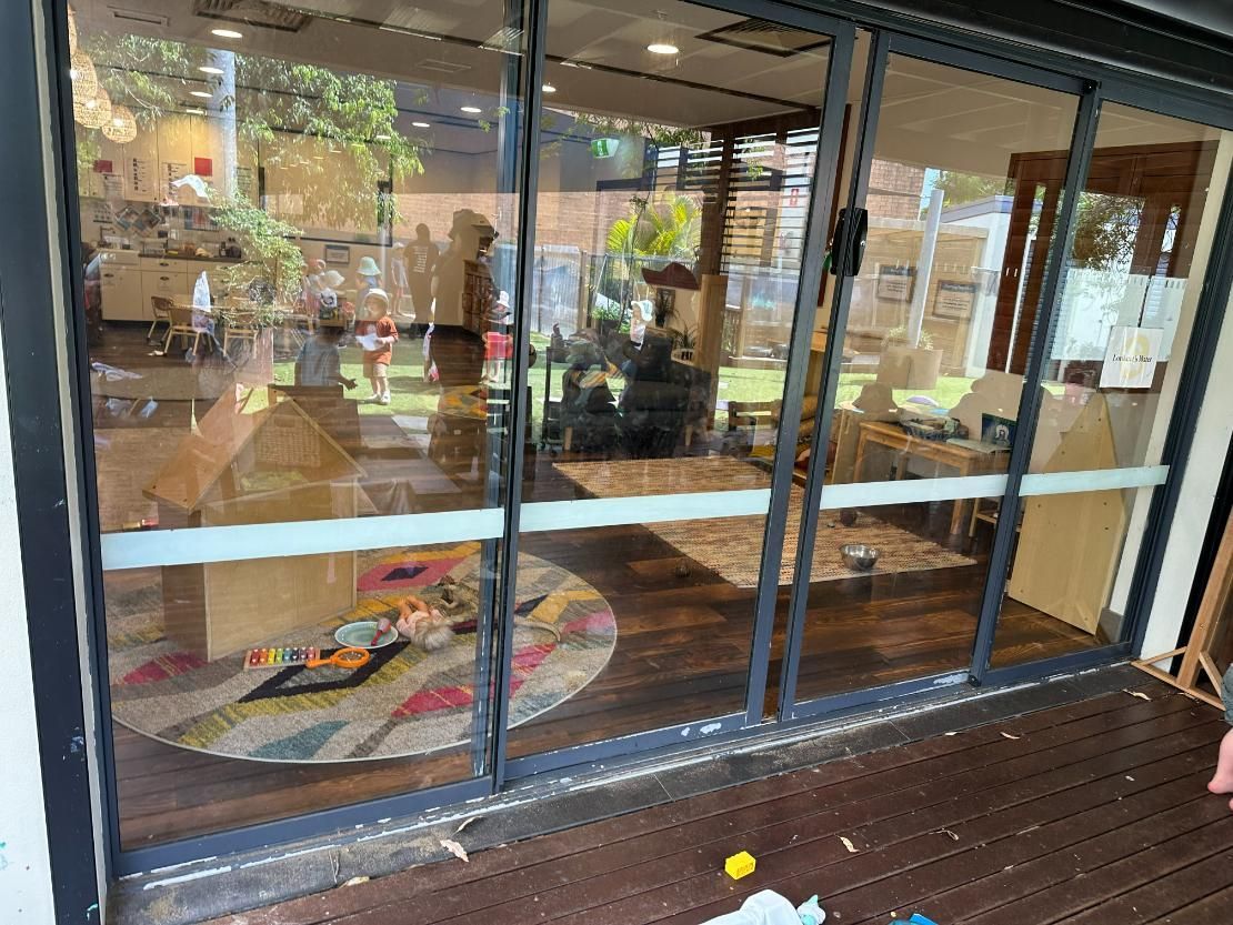 A Room With A Lot Of Windows And A Wooden Floor — Central Coast Glass & Glazing In Umina Beach, NSW