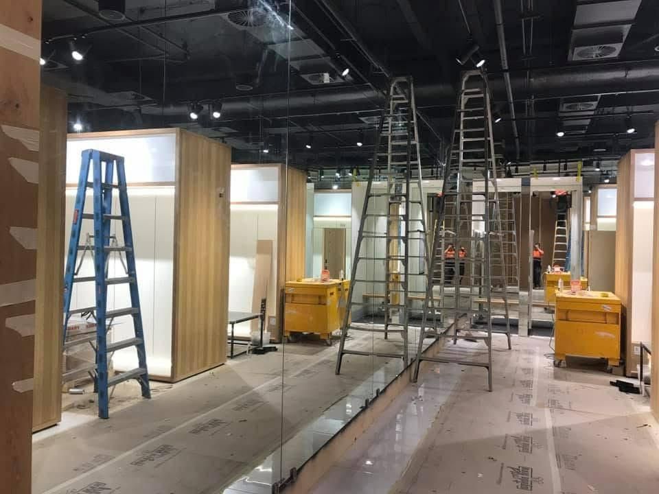 A Ladder Is Sitting In The Middle Of A Room With A Large Mirror — Central Coast Glass & Glazing In Umina Beach, NSW