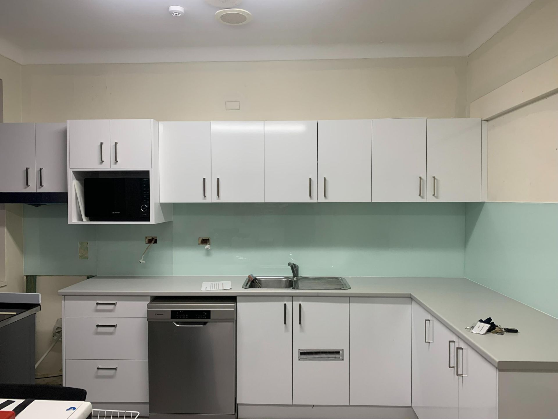 A Kitchen With White Cabinets And A Stainless Steel Dishwasher — Central Coast Glass & Glazing In Umina Beach, NSW