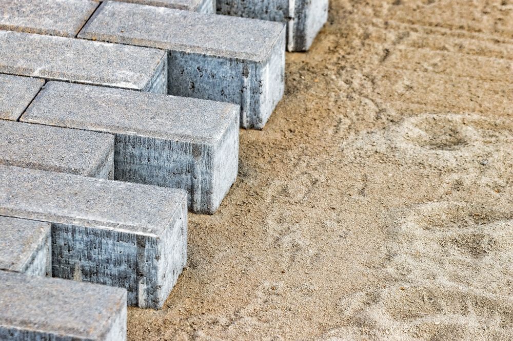 A row of bricks sitting on top of a pile of sand.