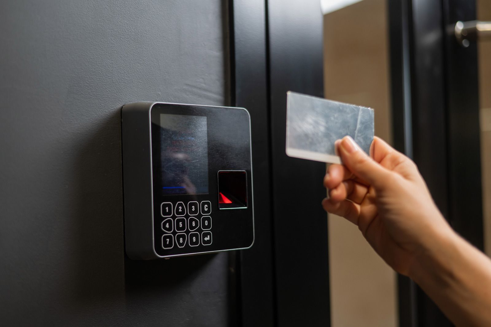 A person is using a fingerprint scanner to open a door.