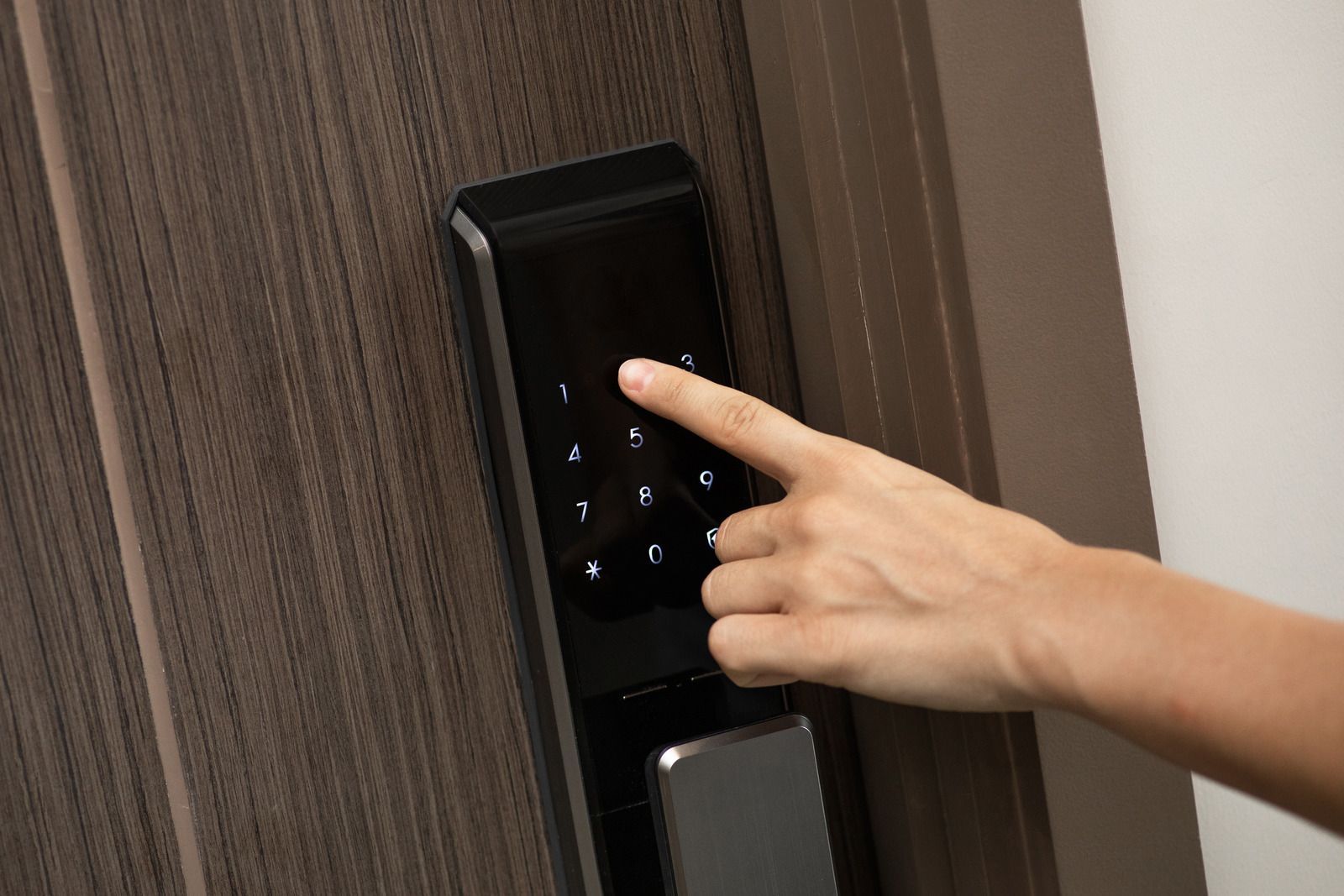 A person is pressing a button on a door lock.