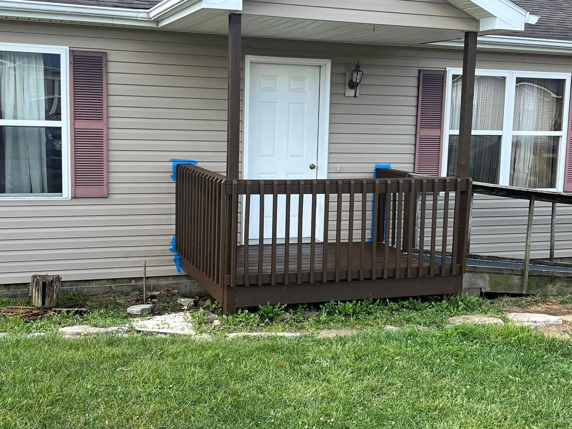 A house with a porch and a ramp in front of it.