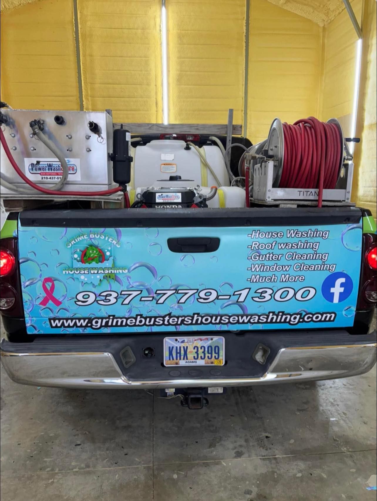 The back of a truck with a hose attached to it.