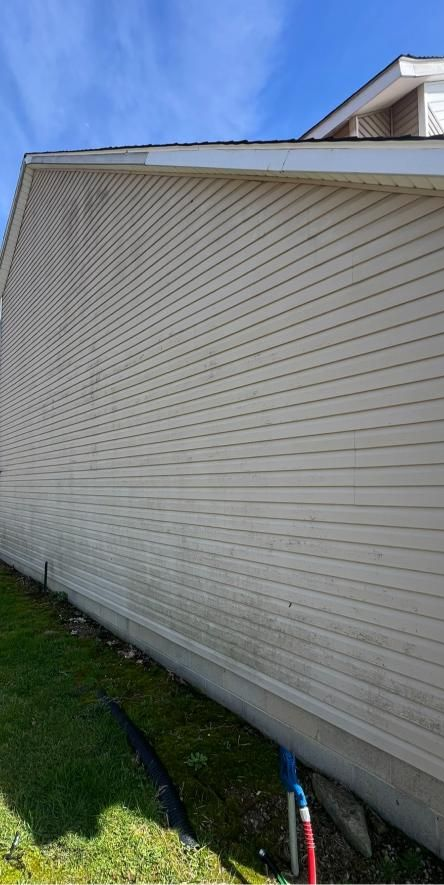 A porch with a wooden table and shutters on a house.