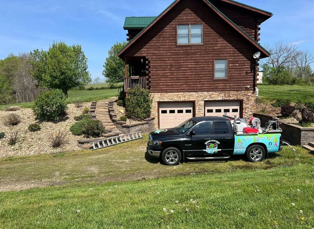 A truck is parked in front of a log cabin.