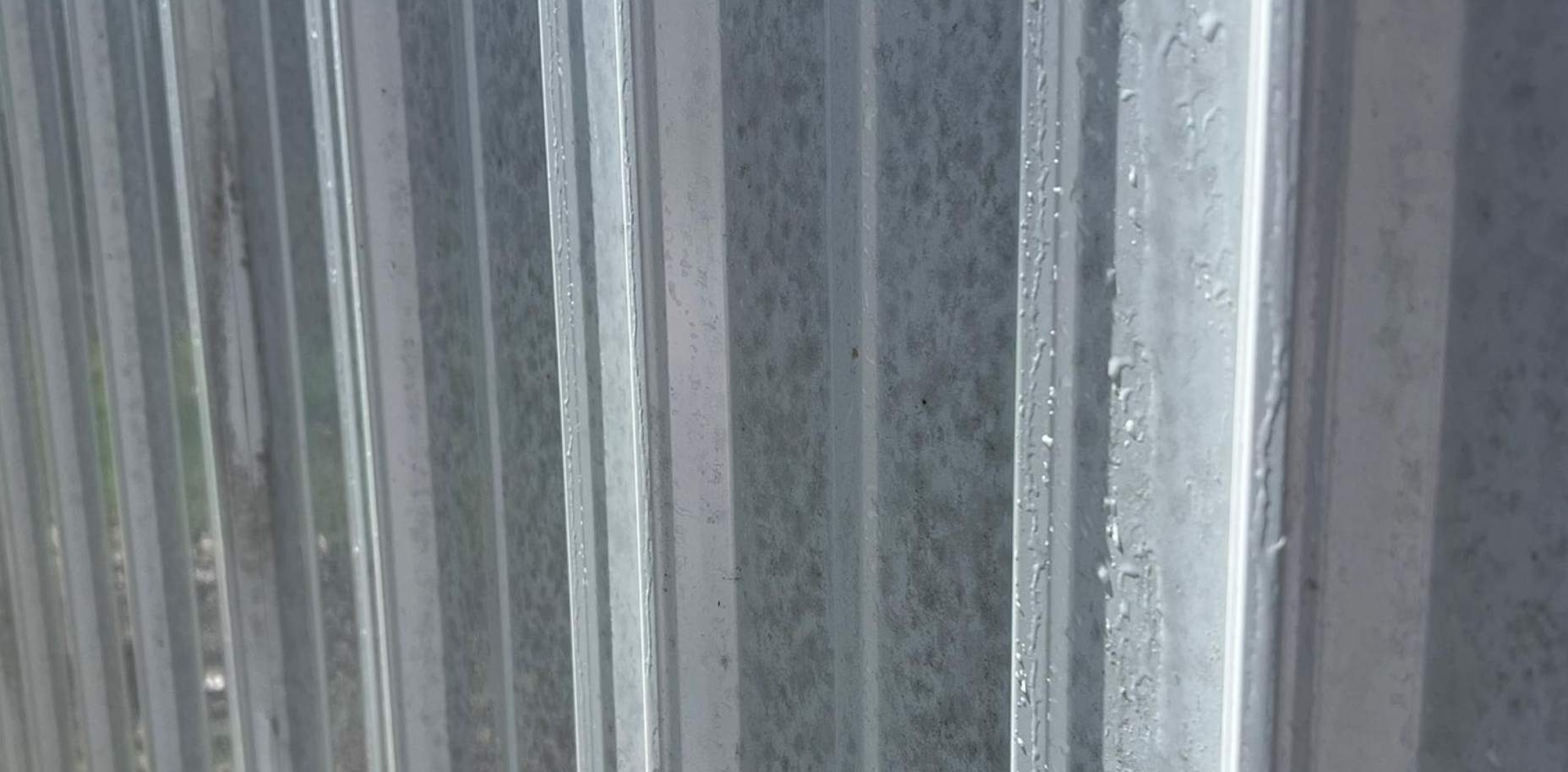 A porch with a wooden table and shutters on a house.