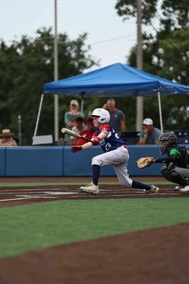 Baseball player sliding into home plate, catcher in front. Blue and gold uniforms, action shot.