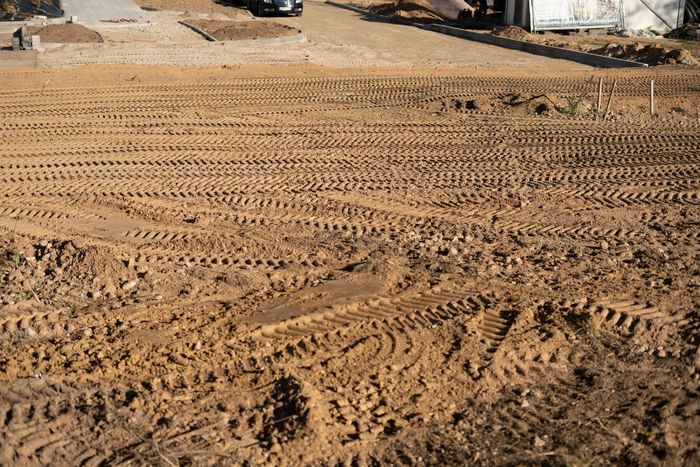 A construction worker is standing in an empty building looking at a tablet. A construction worker is standing in an empty building looking at a tablet.