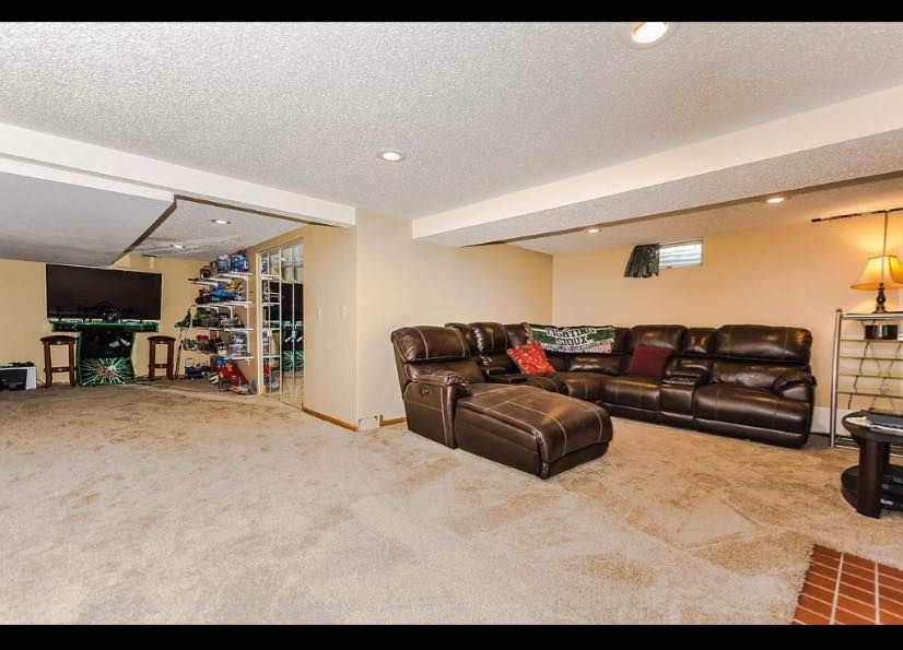 A living room with a large sectional couch and ottoman