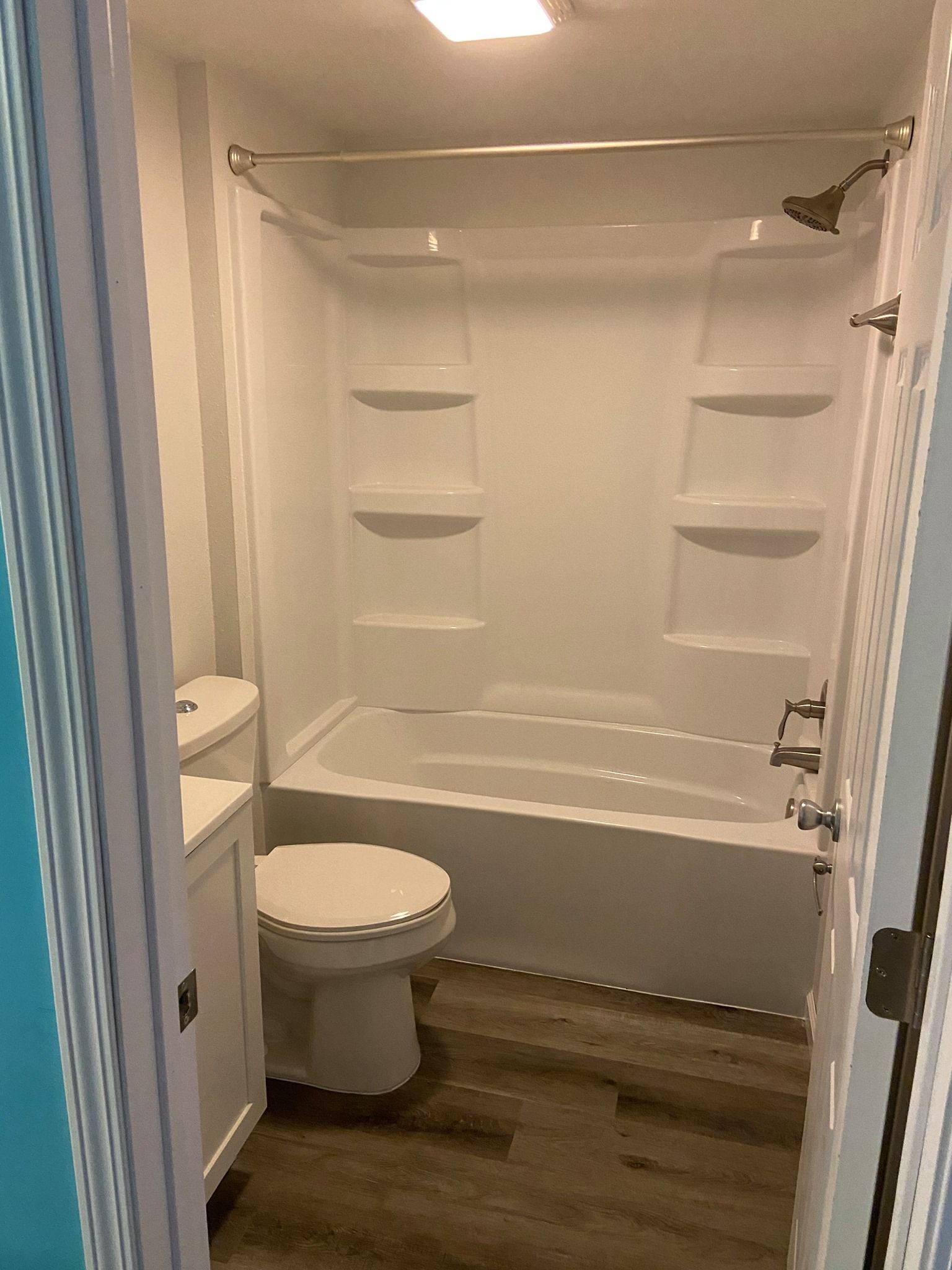 A bathroom with a toilet , tub and shower.