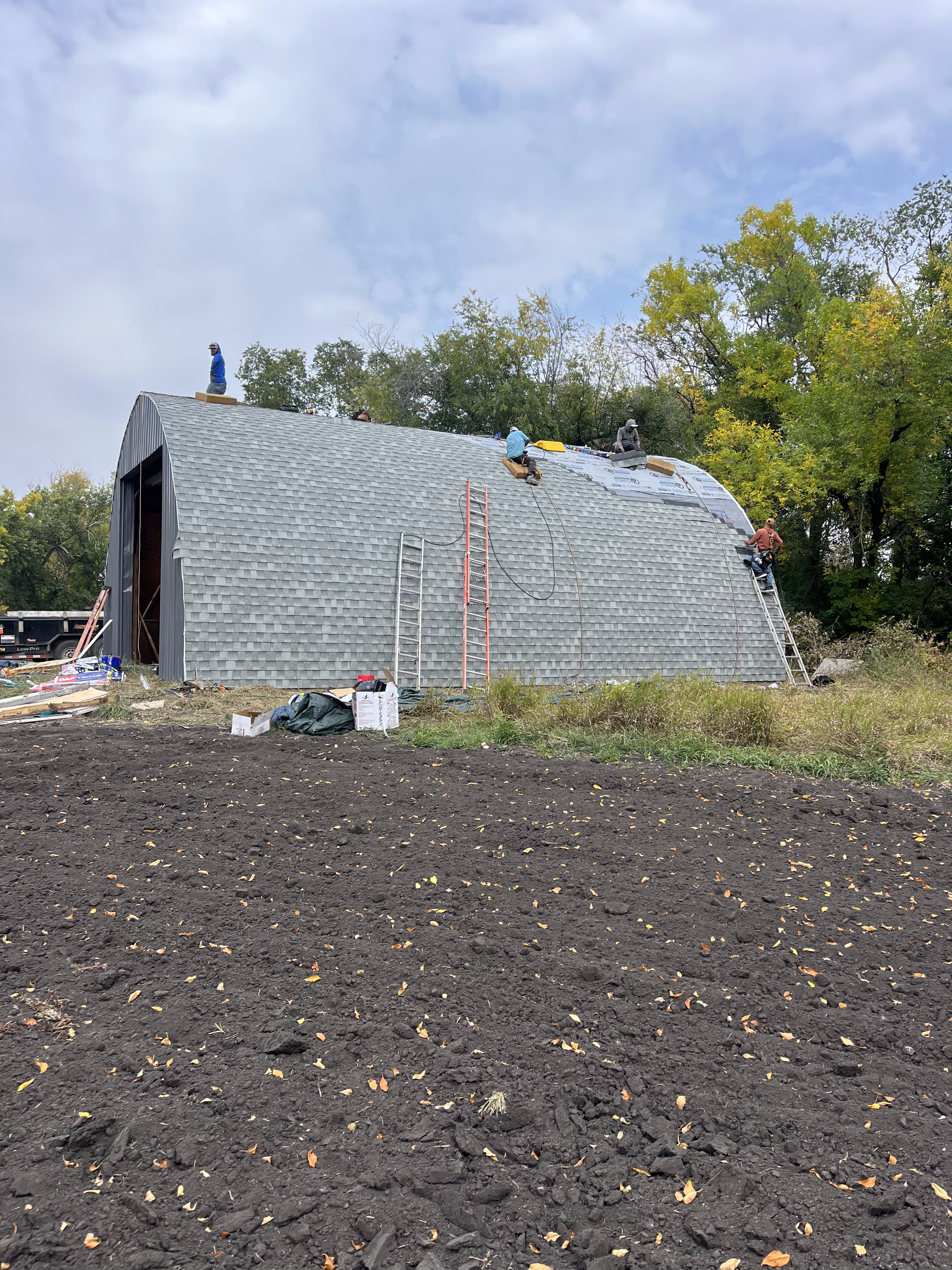 Installing shingles on a farm barn