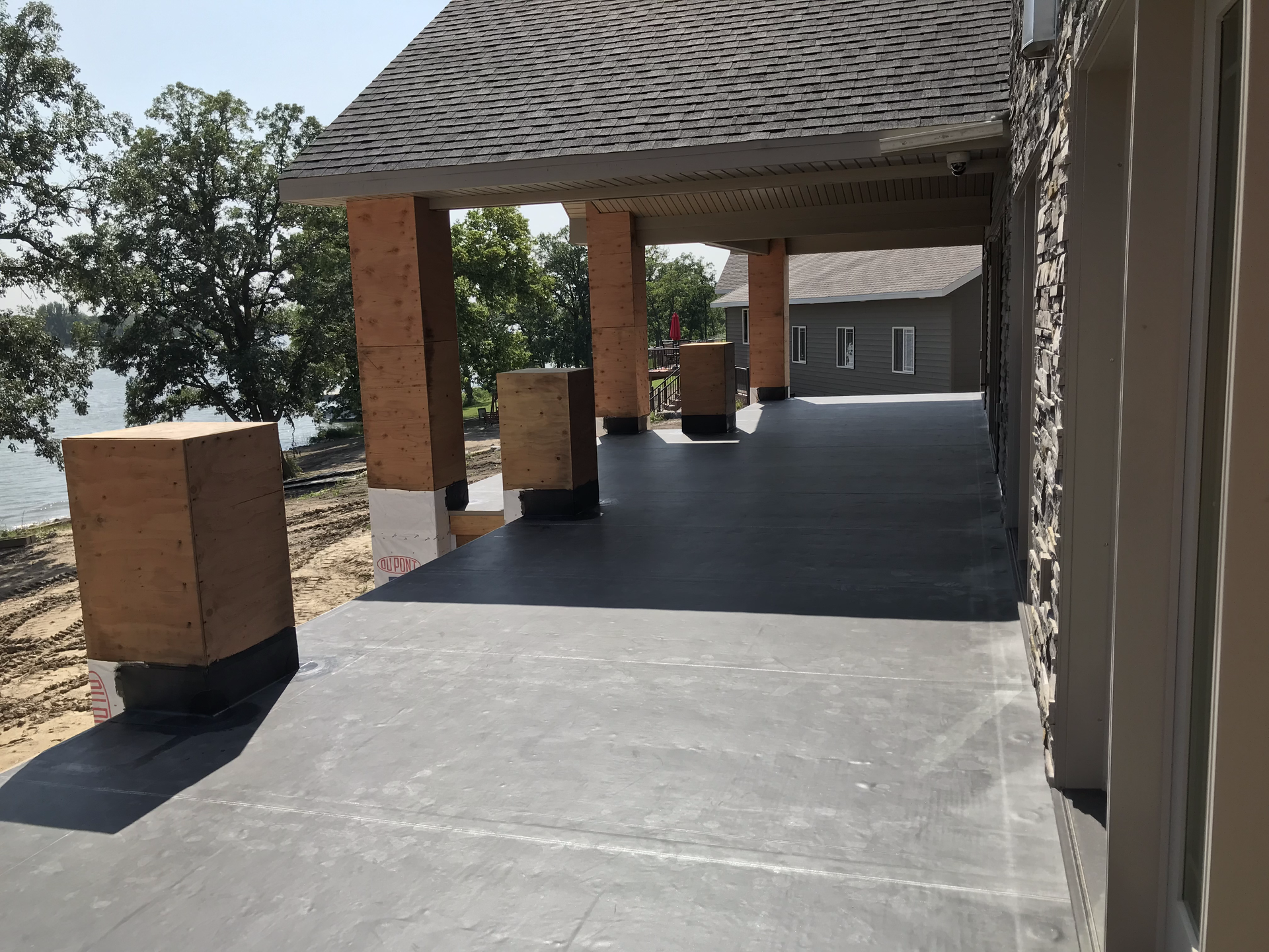 A large covered patio with a view of a lake