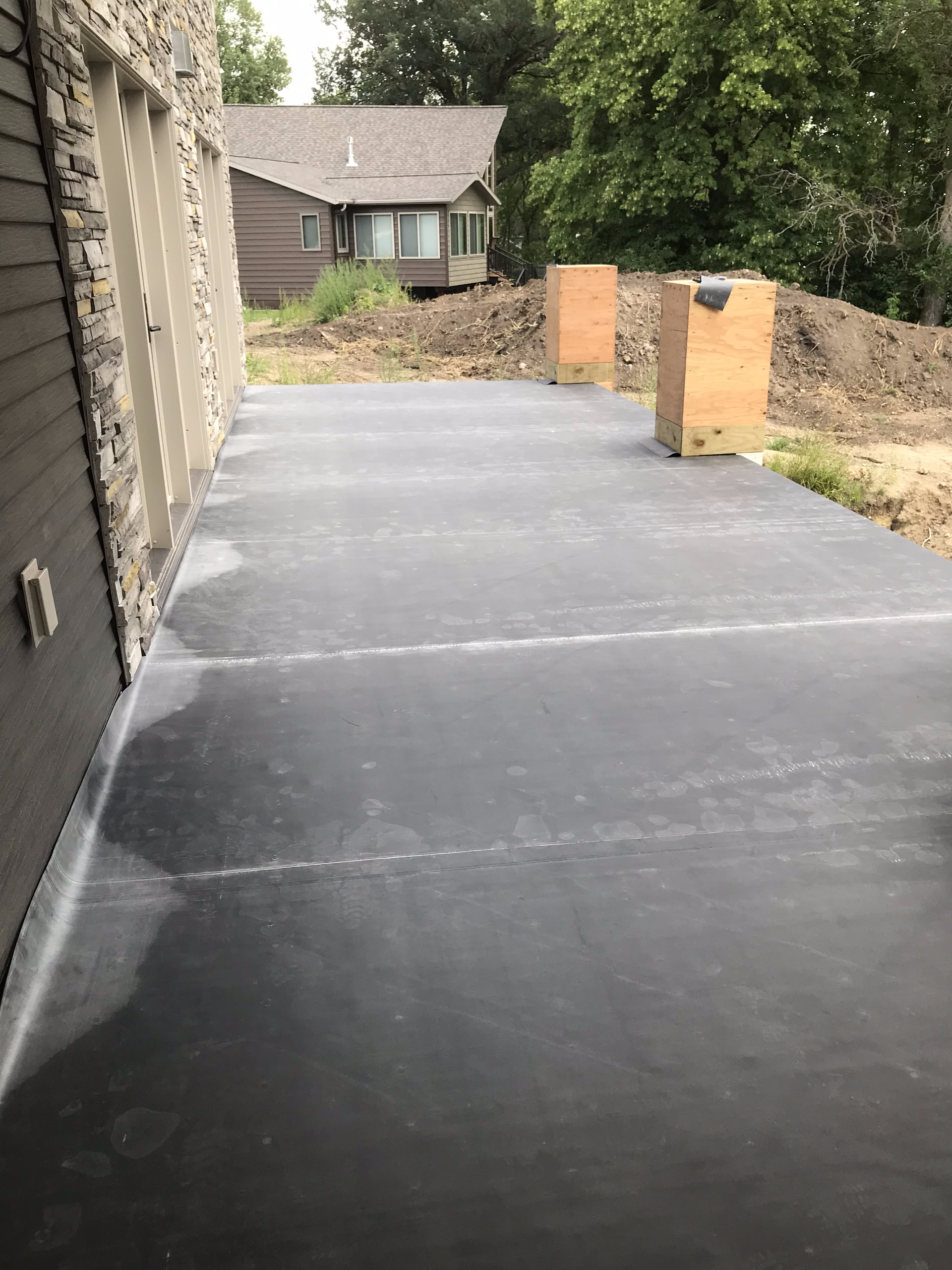 A concrete driveway is being built in front of a house.