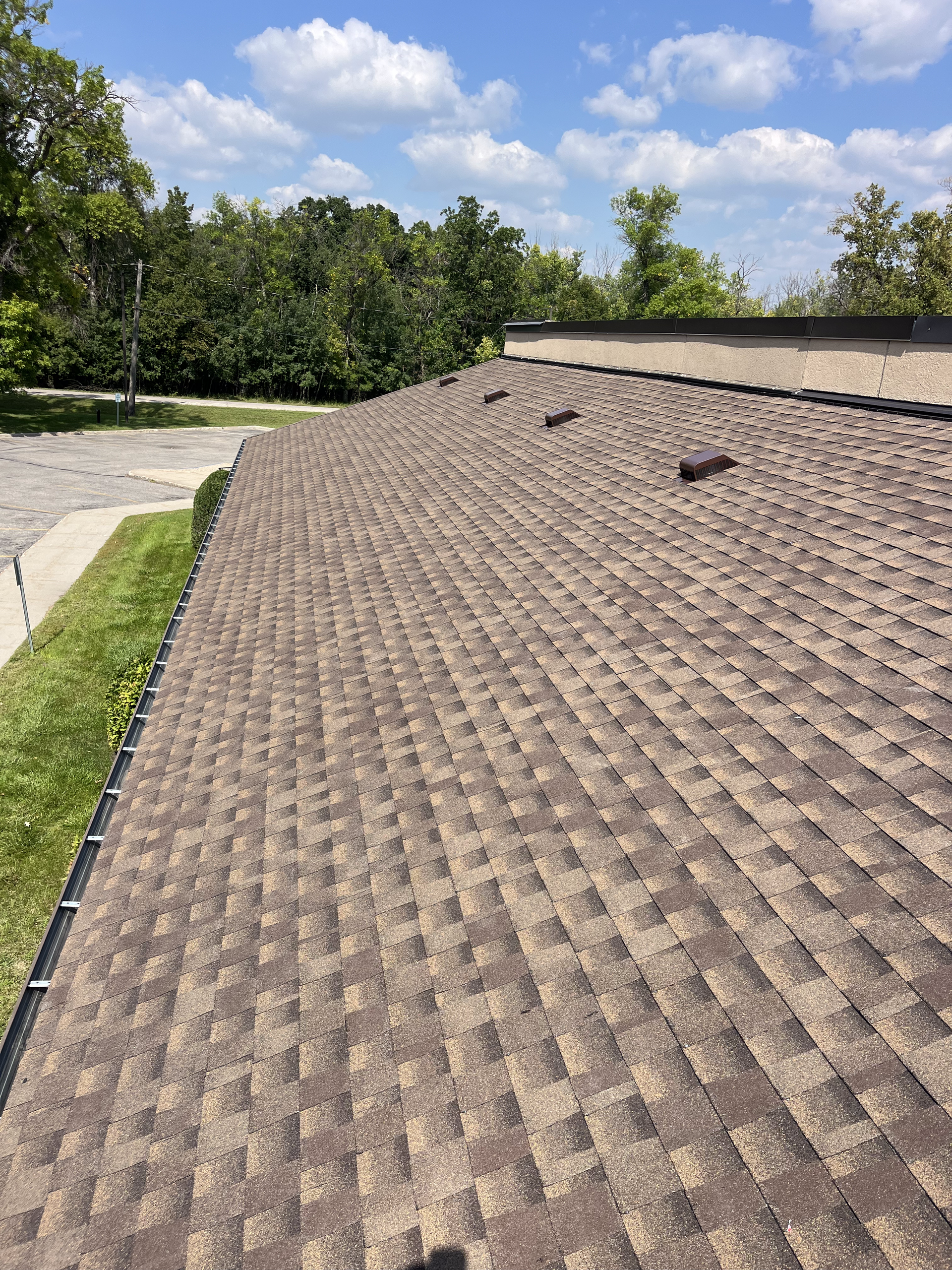 A roof with a lot of shingles on it and a blue sky in the background. Roofing Replacement and Installation