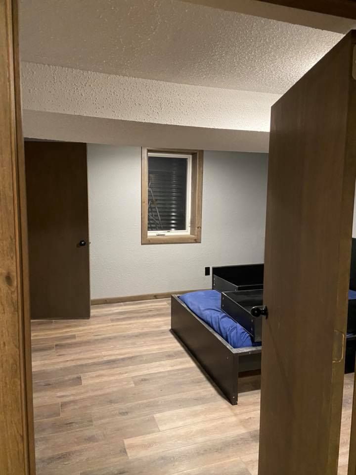 A bedroom with a bed and a window.