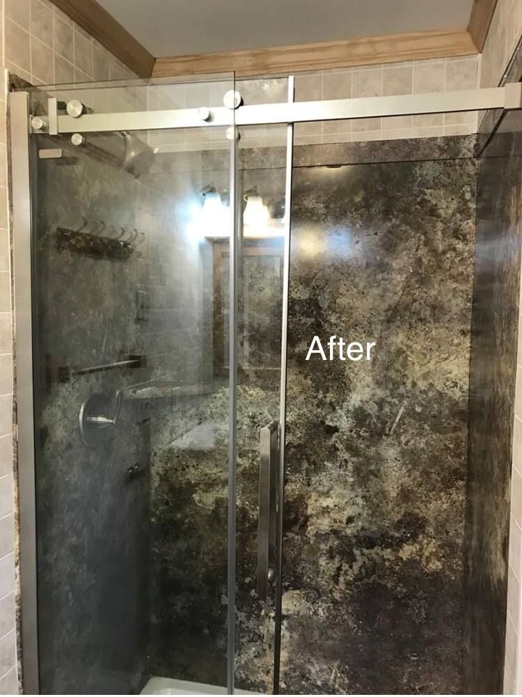 A shower stall with a sliding glass door in a bathroom.