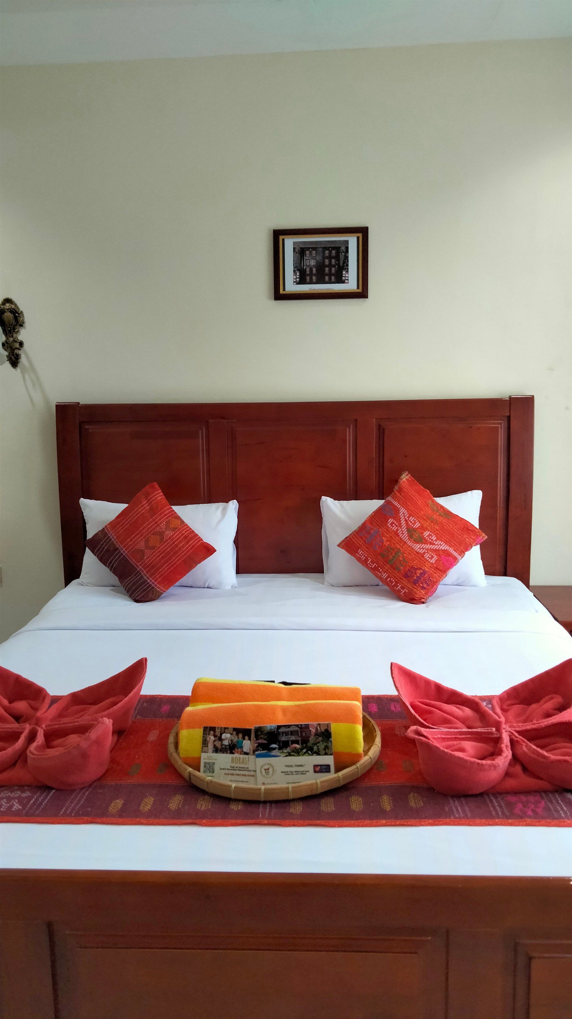 A hotel room with a bed , pillows , towels and candles.