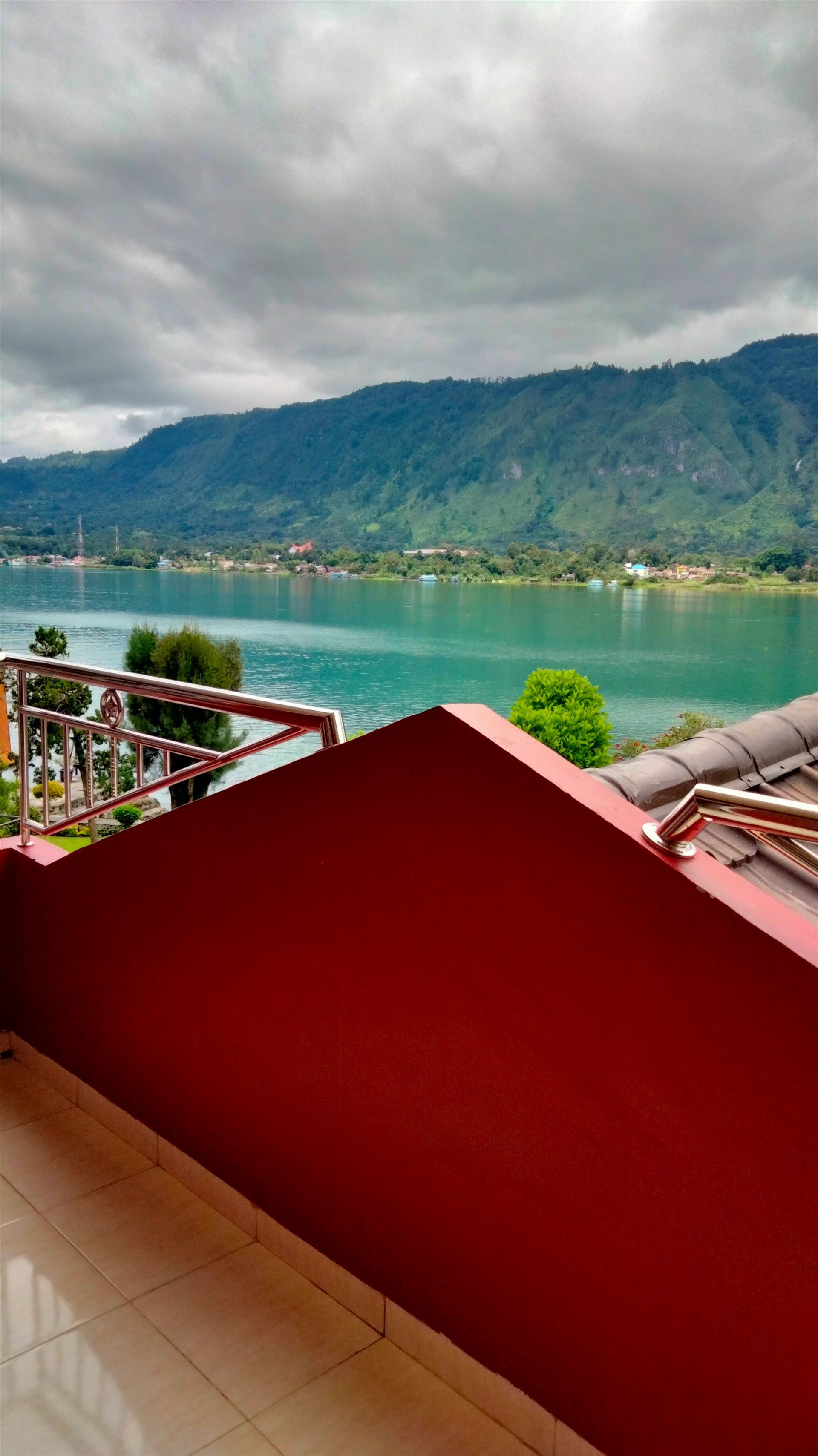 A balcony with a view of a lake and mountains.