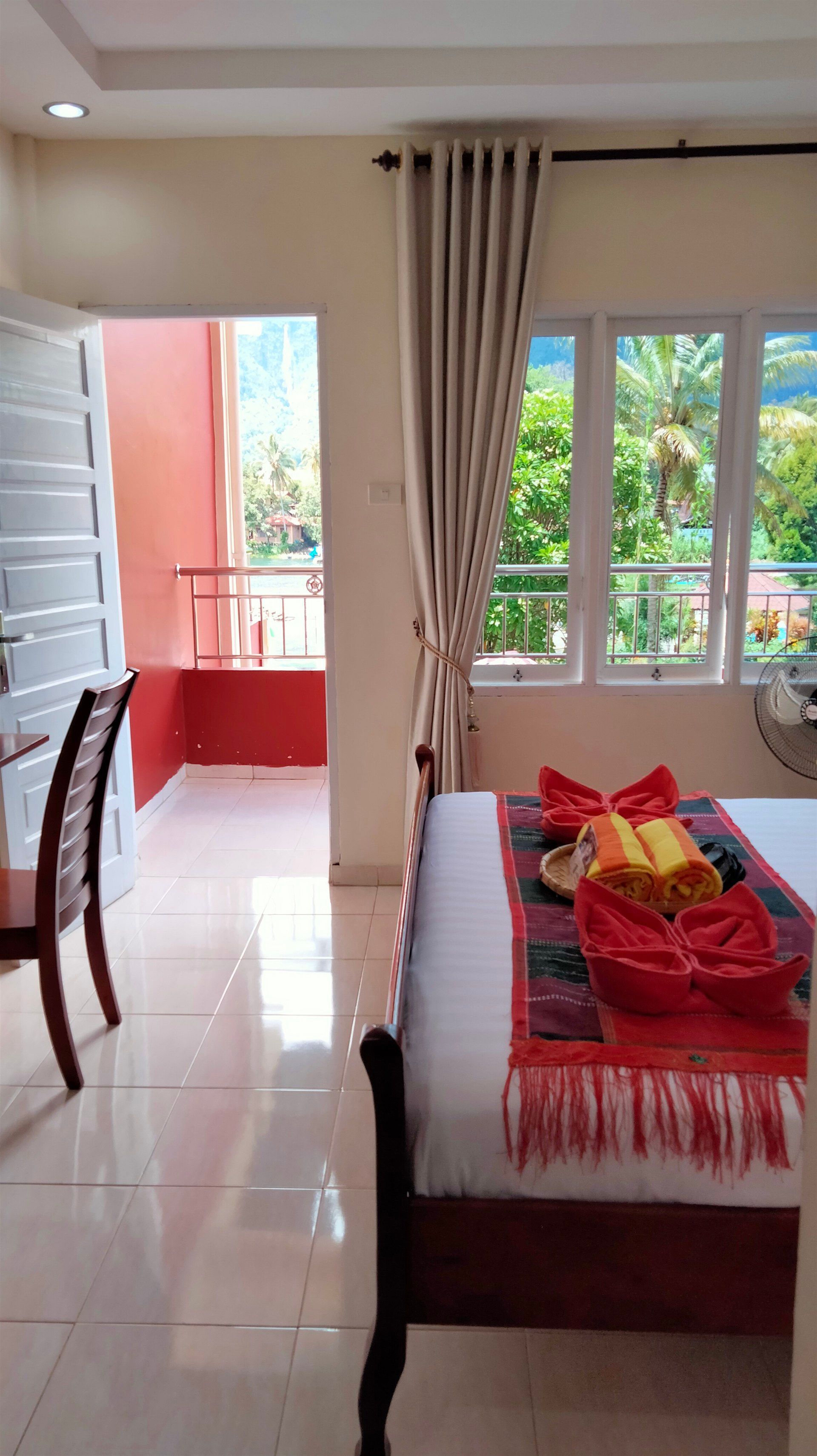 A bedroom with a bed , chair , desk and window.