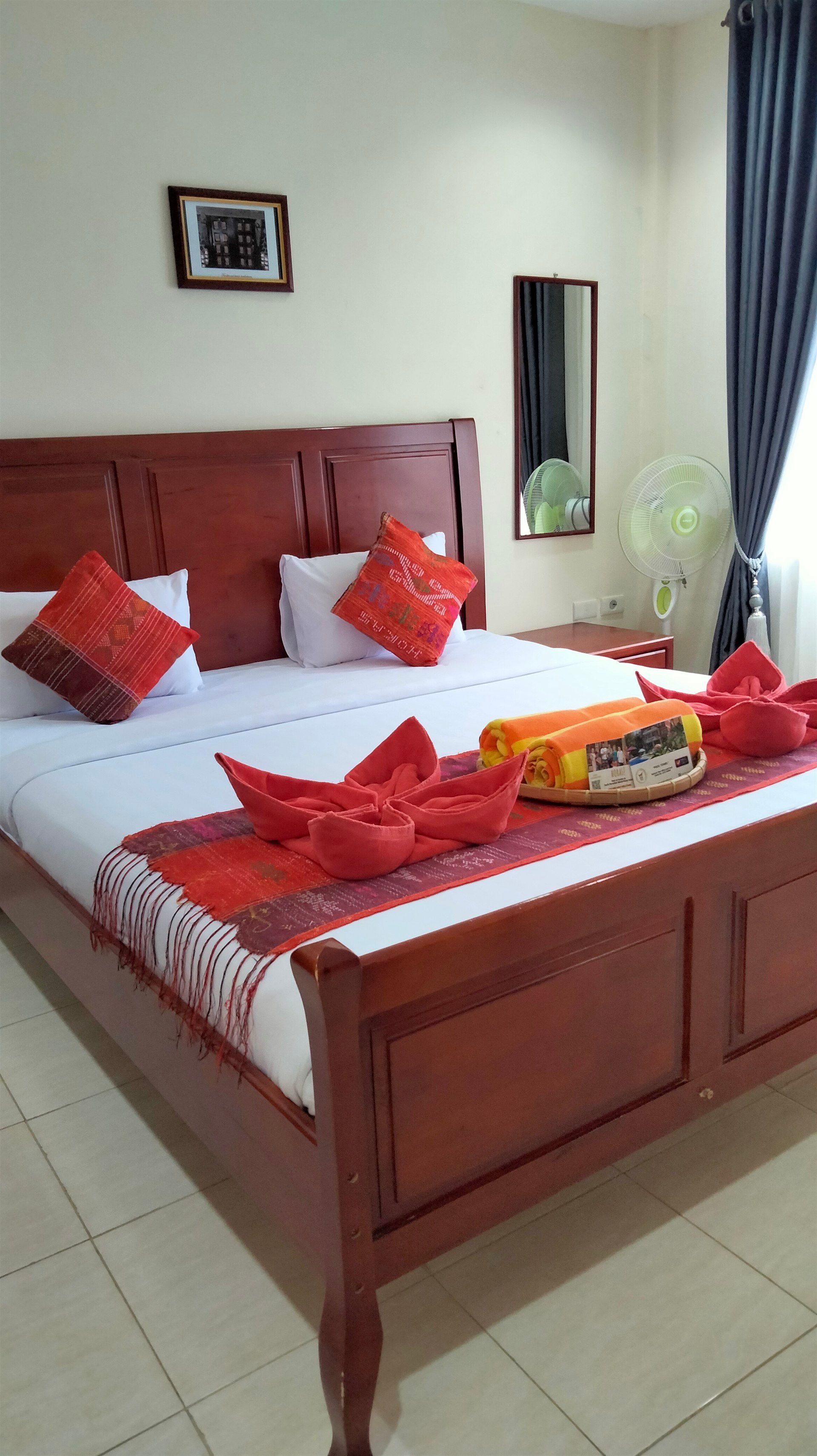 A hotel room with a large bed and a mirror.