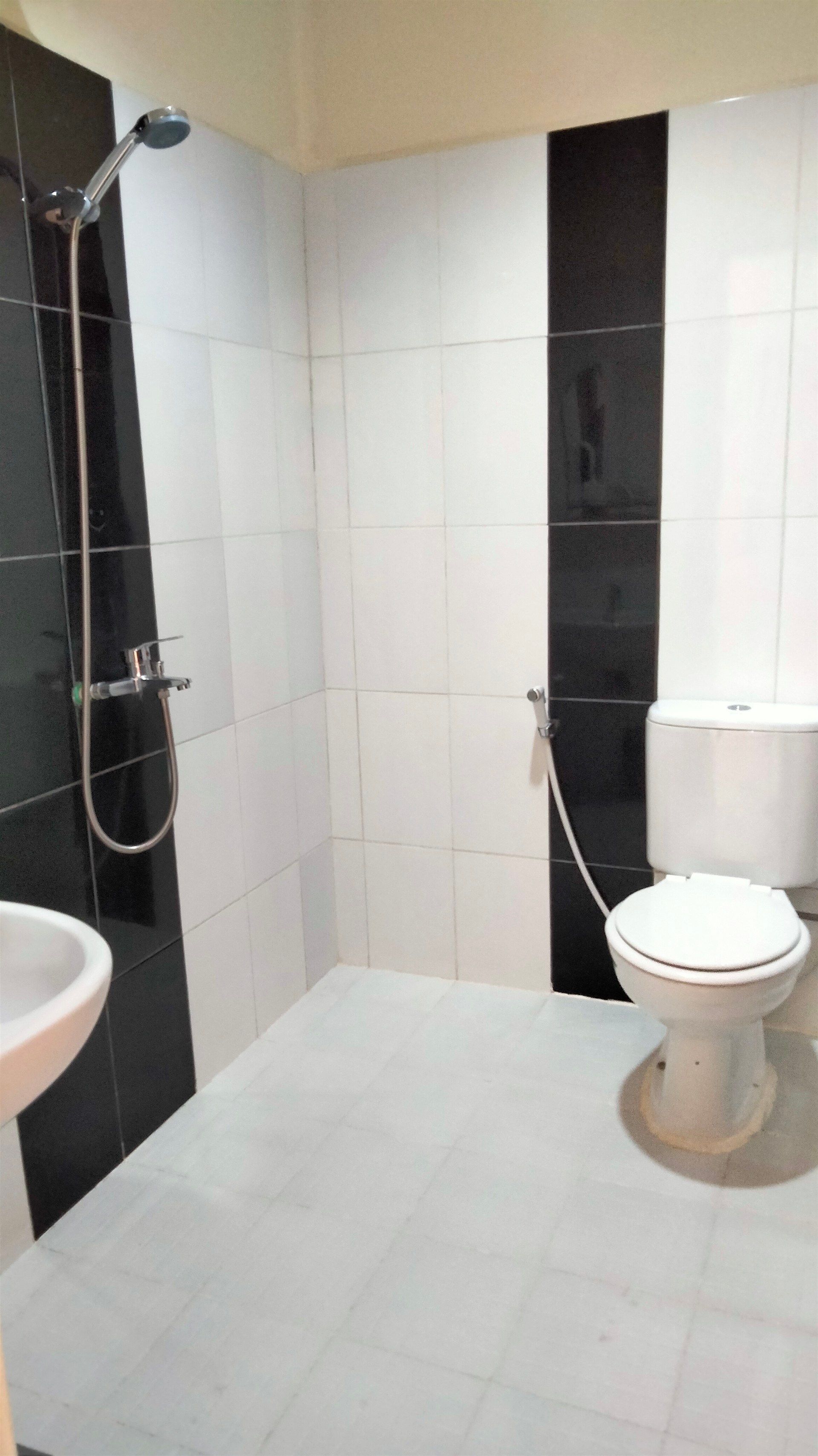 A bathroom with a toilet , sink and shower.