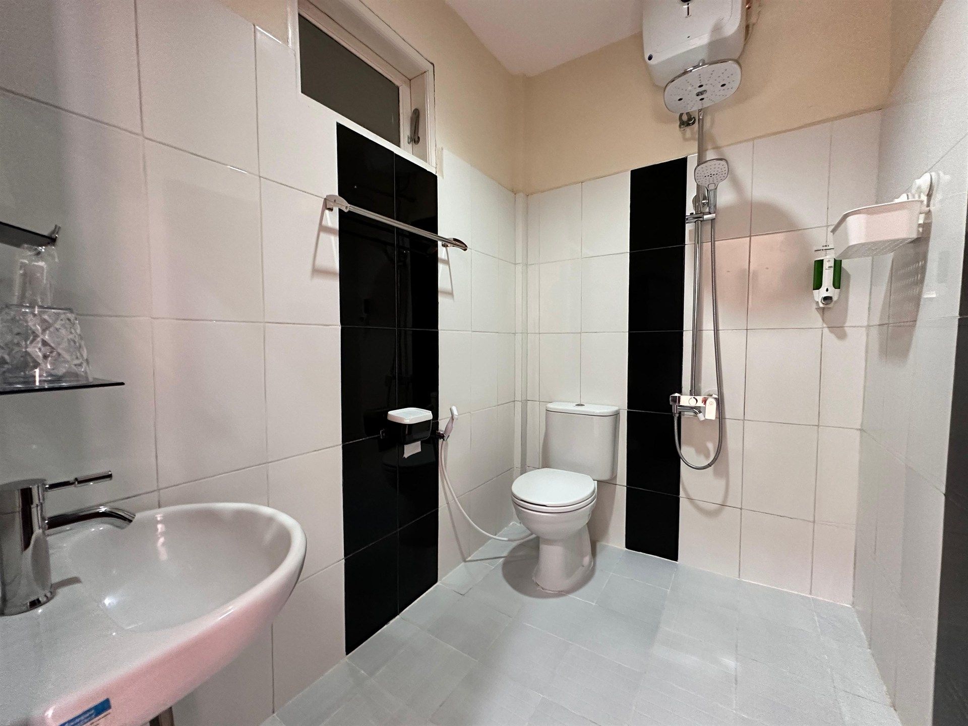 A bathroom with a toilet , sink and shower.