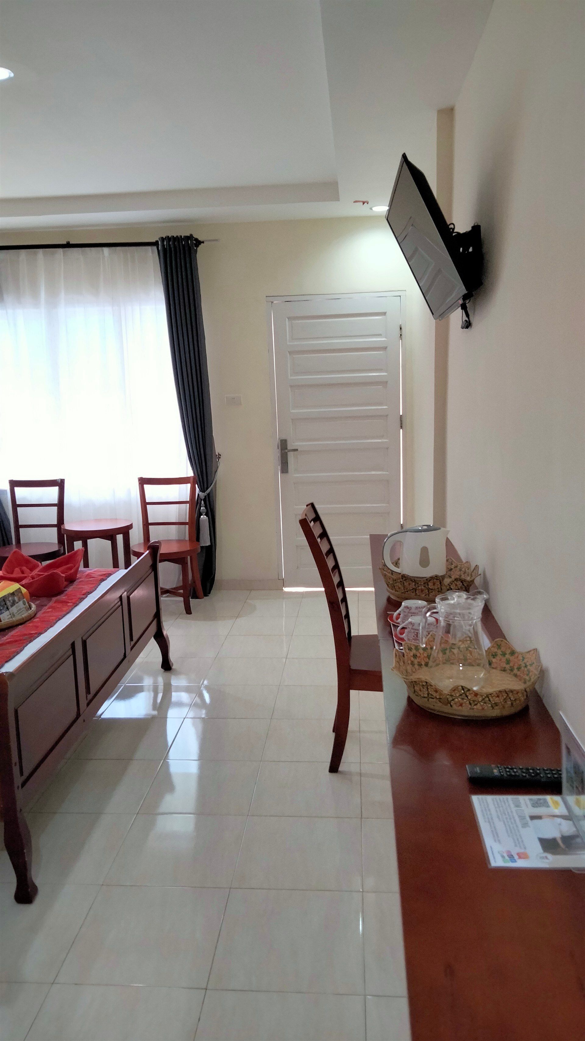 A hotel room with a bed , chairs , desk and television.