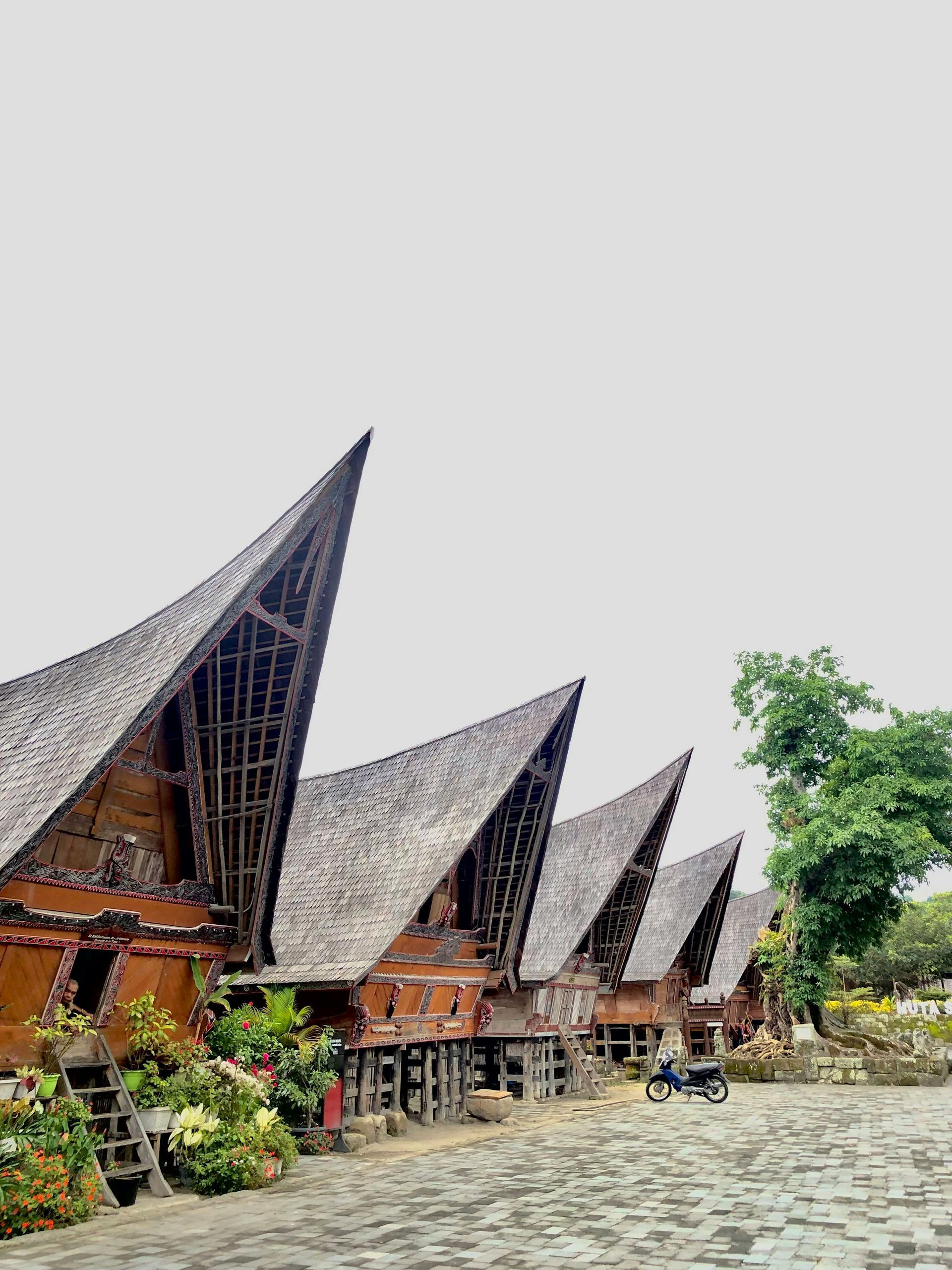 A row of houses with thatched roofs are lined up in a row.