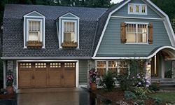 A house with a garage and a barn roof.