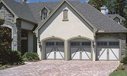 A large house with two garage doors and a driveway.