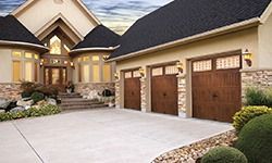A large house with three garage doors in front of it.