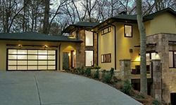 A large house with a garage door and a driveway leading to it.