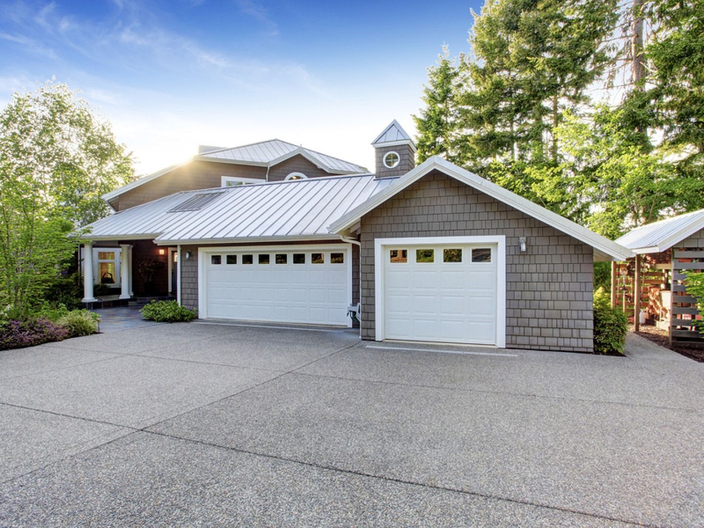 A large house with two garage doors and a driveway.