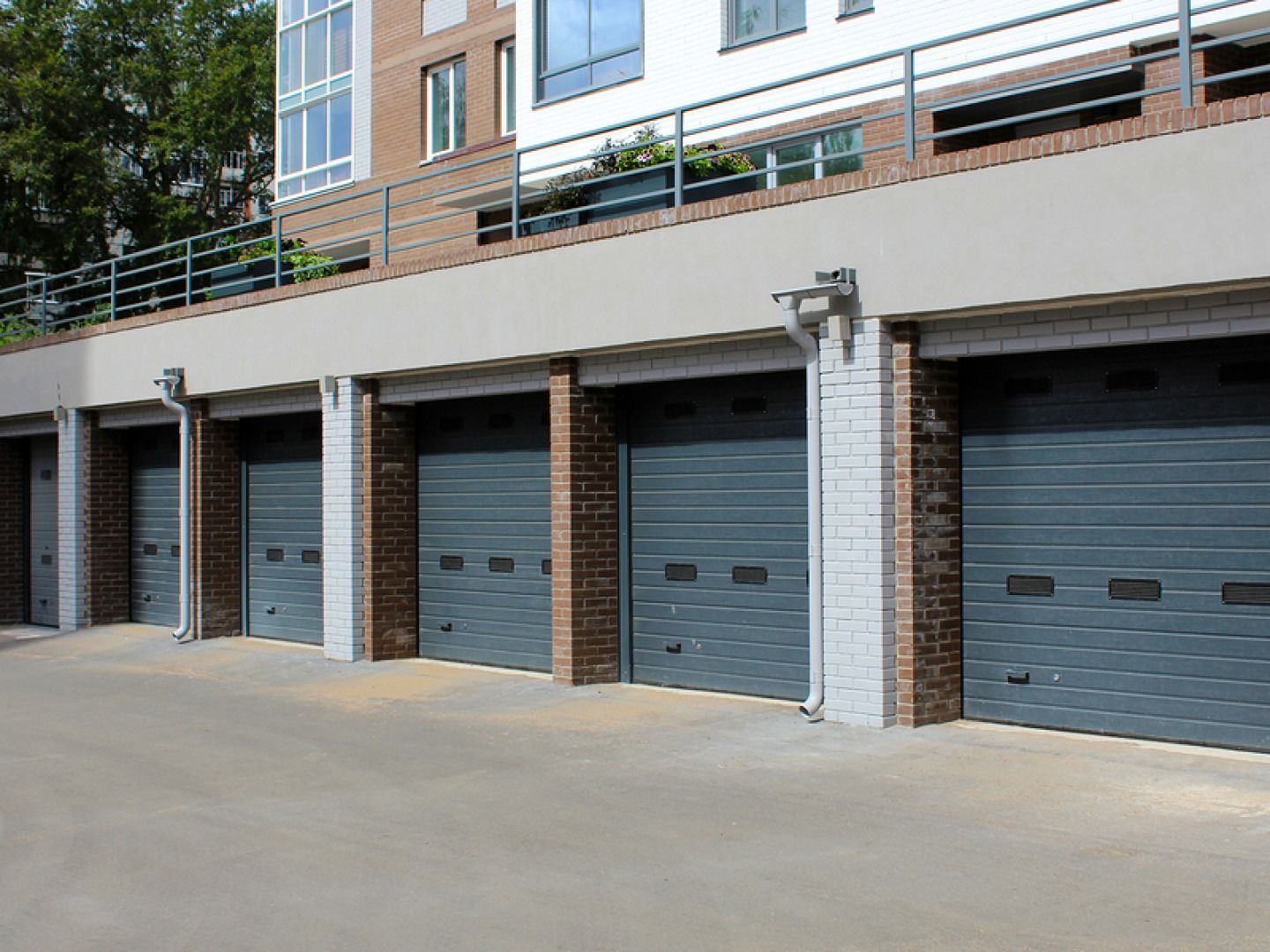 A row of garage doors are lined up in front of a building.