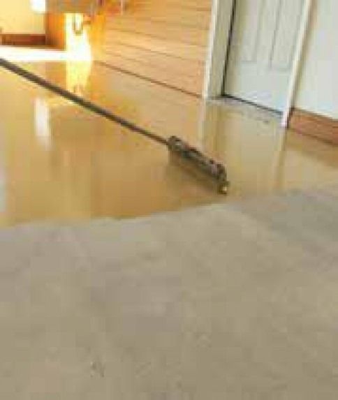A mop is sitting on a wooden floor in a room.